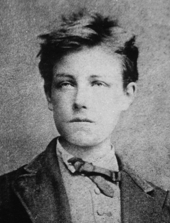 Photographie en noir et blanc d'un adolescent aux cheveux en bataille et au regard clair, en veste et cravate nouée