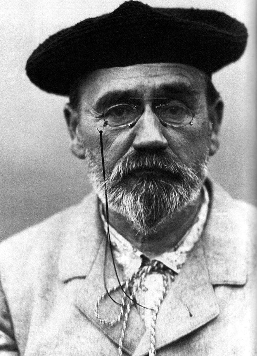 Photographie en noir et blanc d'un homme âgé à barbe grise, coiffé d'un béret, un lorgnon sur le nez