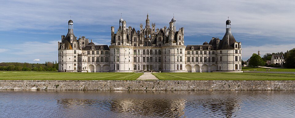 Façade d'un château de la Renaissance, avec toits à lanternons et plan d'eau