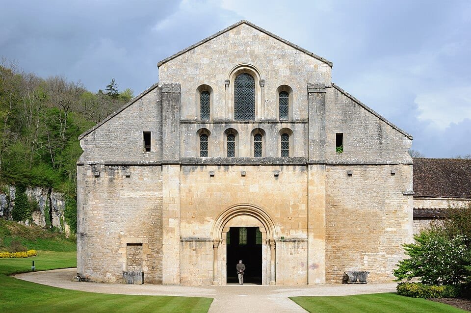 Façade d'une église romane en pierre claire, avec un grand pignon