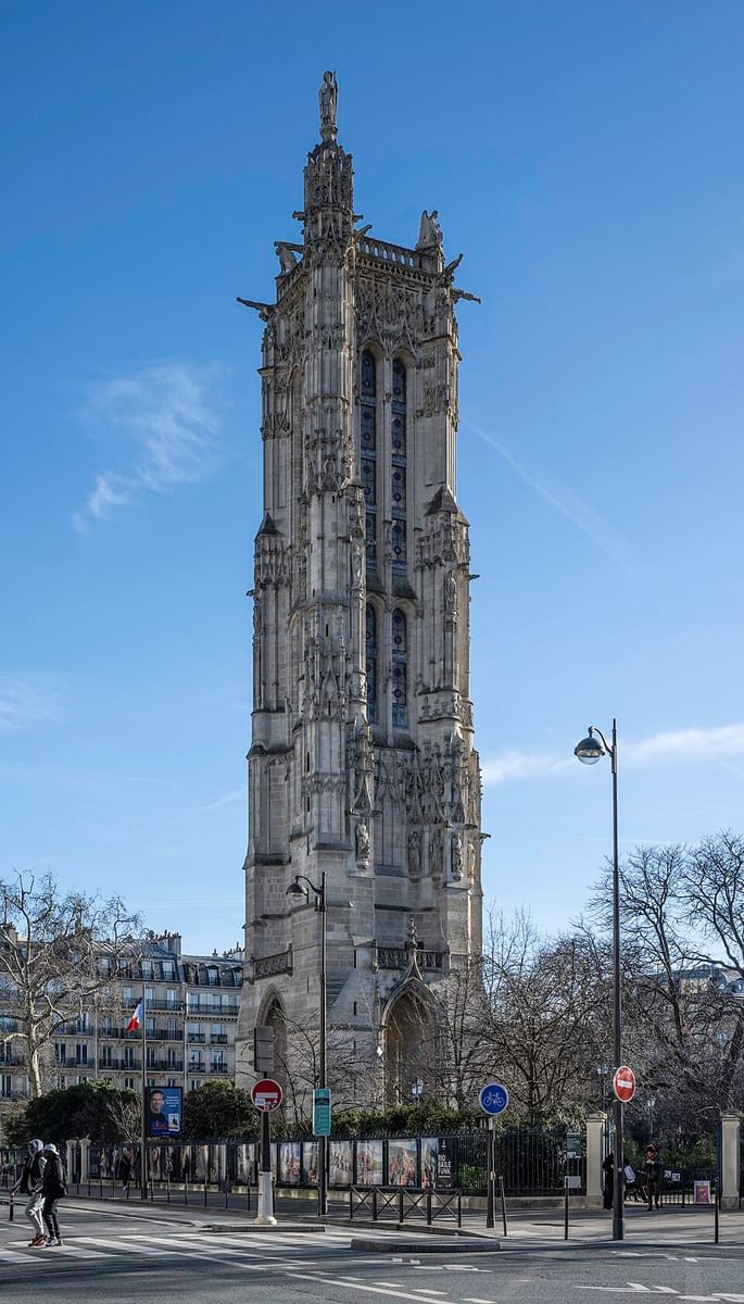Tour gothique haute et sculptée, au milieu d'une rue de Paris