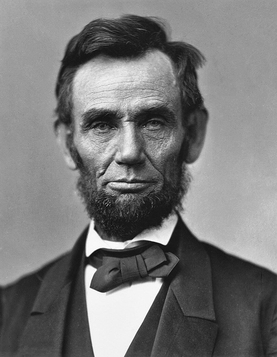 Photographie en noir et blanc d'un homme âgé, au visage creusé, portant une barbe sans moustache et un nœud papillon