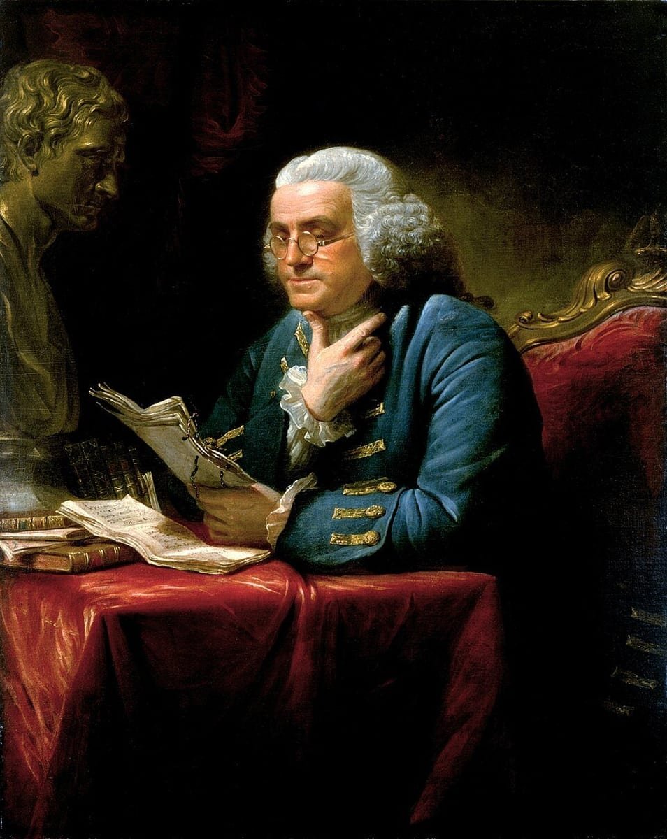Portrait d'un homme âgé à perruque grise et lunettes, en habit bleu, lisant un papier près d'un buste de bronze